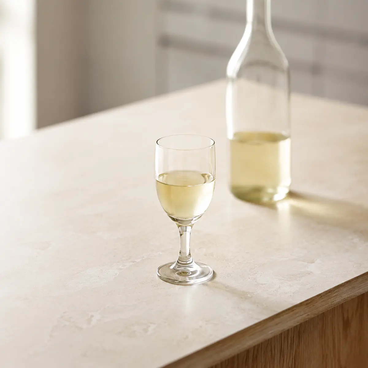 Xérès sec : un verre à pied à moitié plein, une bouteille sans étiquette derrière.